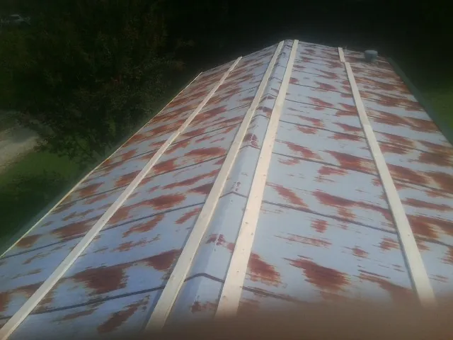 Rusted metal roof panels with new wood purlins before replacement — Storm Damage Roof Repair in Granite Canon by Roofing Brothers