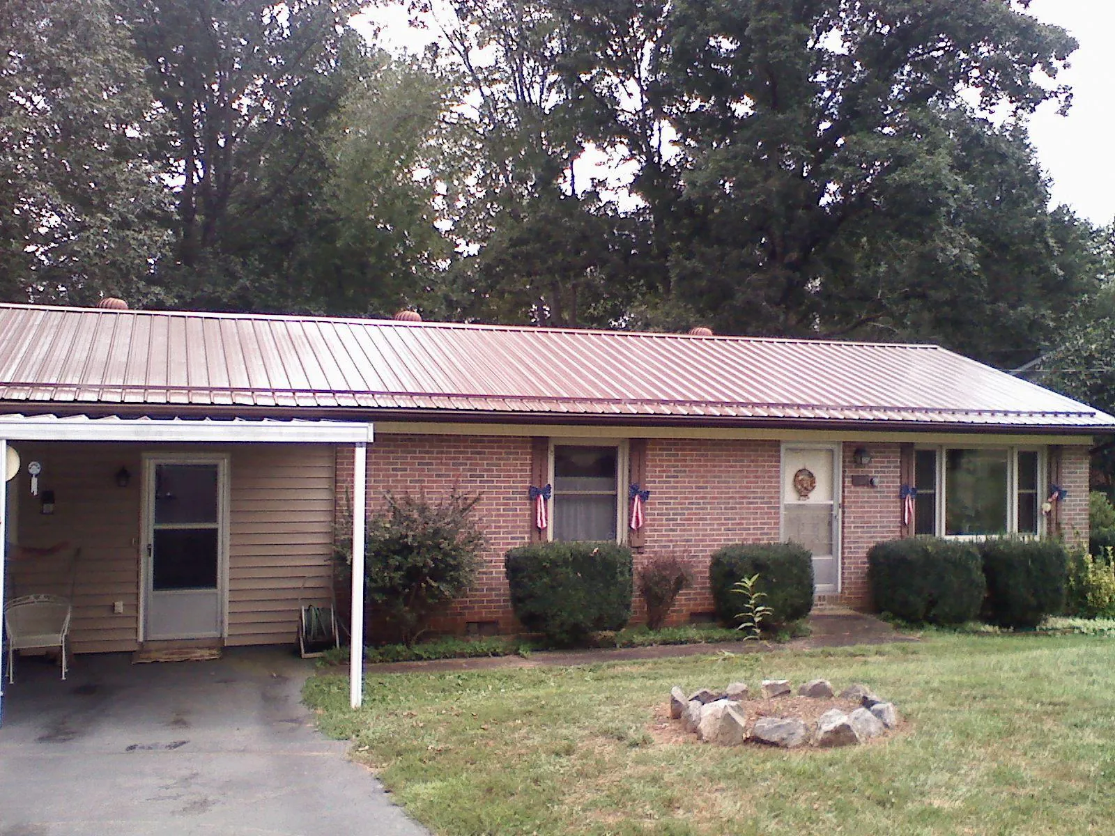 Bronze metal roof and carport on a brick ranch home — Roof Repair work by our crew in Granite Canon